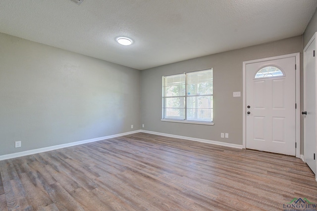 foyer featuring a textured ceiling and light hardwood / wood-style floors