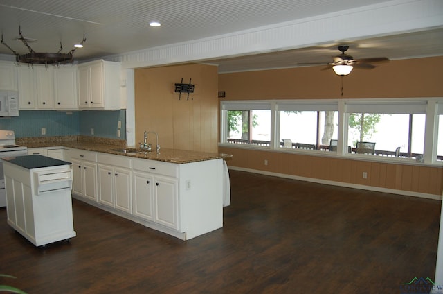 kitchen featuring white appliances, white cabinets, sink, dark hardwood / wood-style floors, and a kitchen island