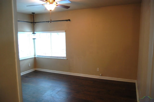 spare room with ceiling fan and dark wood-type flooring