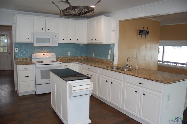 kitchen with a center island, white appliances, dark stone counters, sink, and white cabinetry