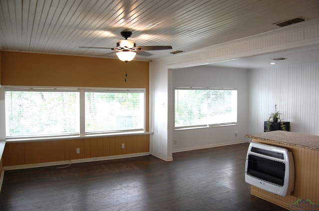 unfurnished living room featuring plenty of natural light, ceiling fan, dark hardwood / wood-style floors, and heating unit