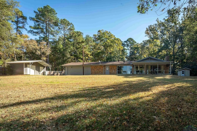 view of front of property with a front yard, a shed, and a carport