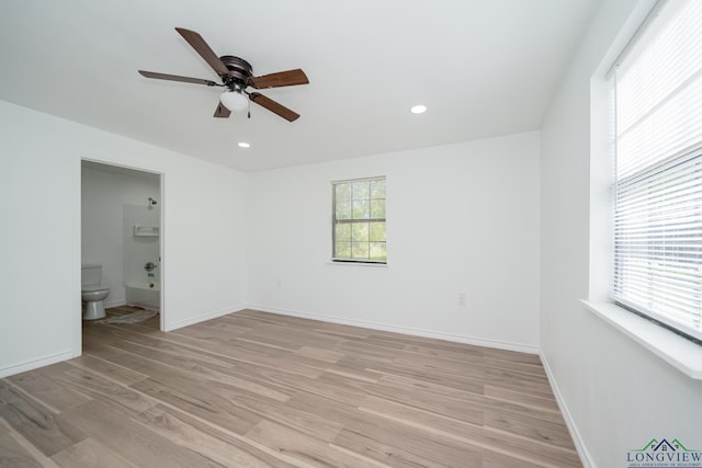 spare room featuring a wealth of natural light, ceiling fan, and light hardwood / wood-style flooring