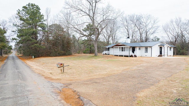 1255 County Road 4305, Naples, TX 75568 - view of front facade featuring metal roof, asphalt driveway, and board and batten siding