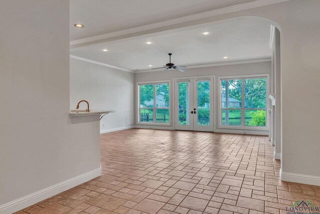 1719 Hg Mosley Pkwy, Longview, TX 75604 - unfurnished living room with baseboards, arched walkways, plenty of natural light, ceiling fan, and recessed lighting