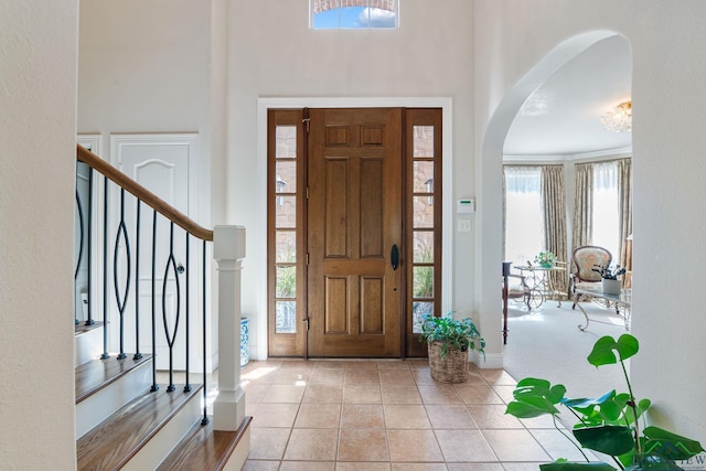 1719 Hg Mosley Pkwy, Longview, TX 75604 - tiled foyer entrance featuring a high ceiling, arched walkways, stairway, and baseboards