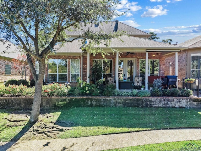 1719 Hg Mosley Pkwy, Longview, TX 75604 - back of property with brick siding, a lawn, roof with shingles, and a ceiling fan