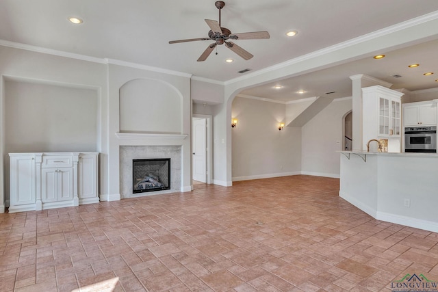 1719 Hg Mosley Pkwy, Longview, TX 75604 - unfurnished living room featuring arched walkways, a ceiling fan, baseboards, a fireplace, and recessed lighting