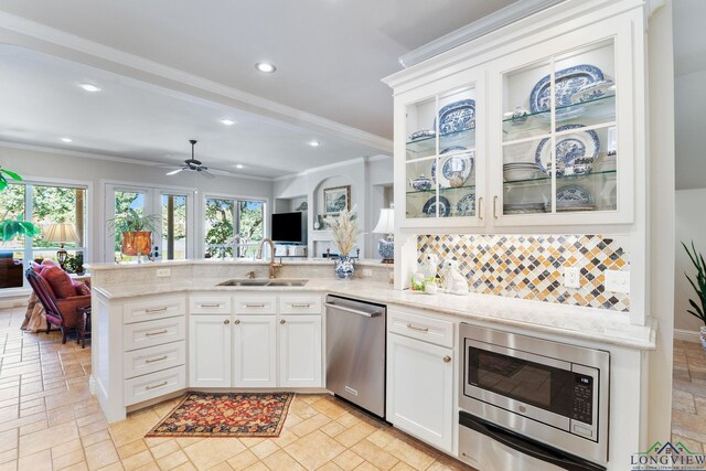 1719 Hg Mosley Pkwy, Longview, TX 75604 - kitchen with stainless steel appliances, a sink, a peninsula, crown molding, and backsplash