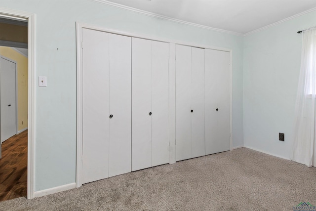 unfurnished bedroom featuring a closet, crown molding, and carpet flooring