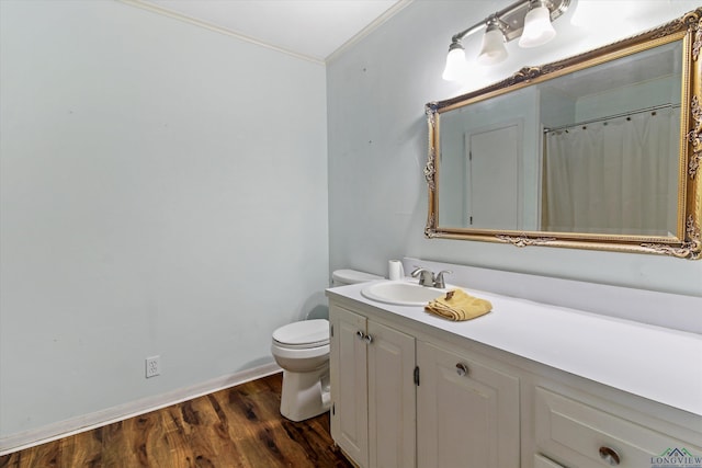 bathroom featuring toilet, wood-type flooring, vanity, and crown molding