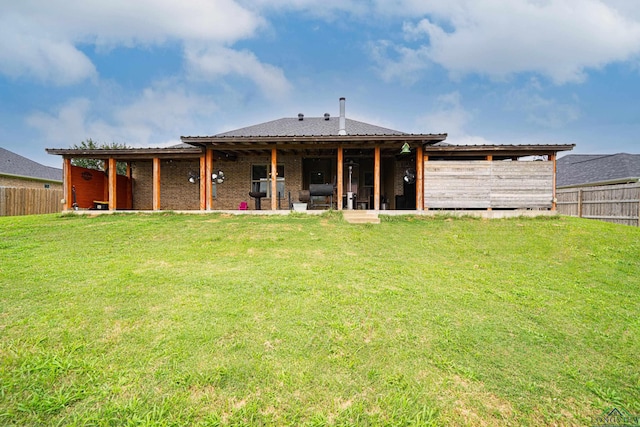 rear view of house featuring a lawn