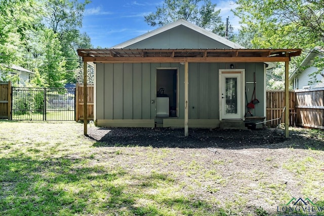 back of property featuring board and batten siding, a fenced backyard, and an outdoor structure
