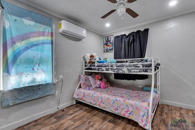 bedroom featuring wood finished floors, ornamental molding, baseboards, a wall mounted AC, and ceiling fan