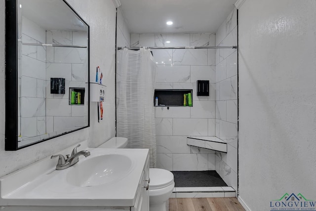 full bathroom with toilet, vanity, wood finished floors, and a stall shower
