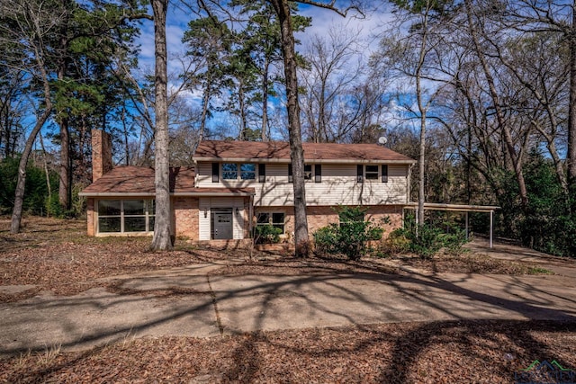 view of front of house with a chimney and brick siding