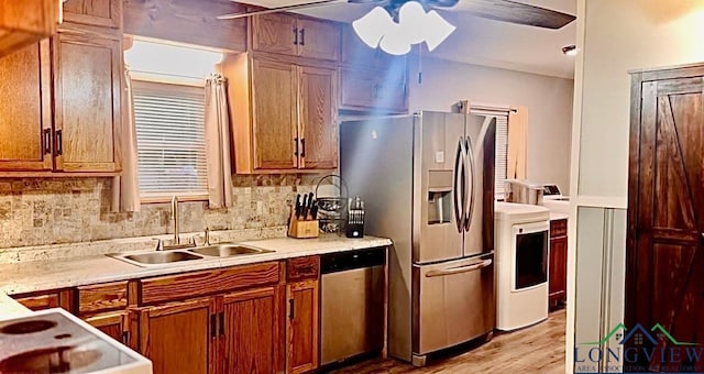 kitchen with appliances with stainless steel finishes, tasteful backsplash, washer / dryer, and sink