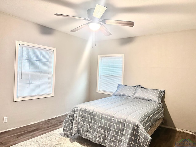 bedroom with ceiling fan and dark wood-type flooring