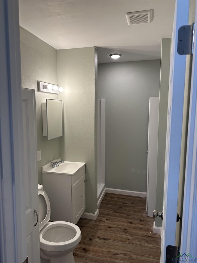 2001 E 20th, Hooks, TX 75561 - bathroom with toilet, wood finished floors, vanity, and baseboards