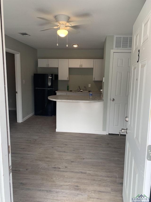 2001 E 20th, Hooks, TX 75561 - kitchen with freestanding refrigerator, a ceiling fan, light wood-style flooring, a peninsula, and light countertops