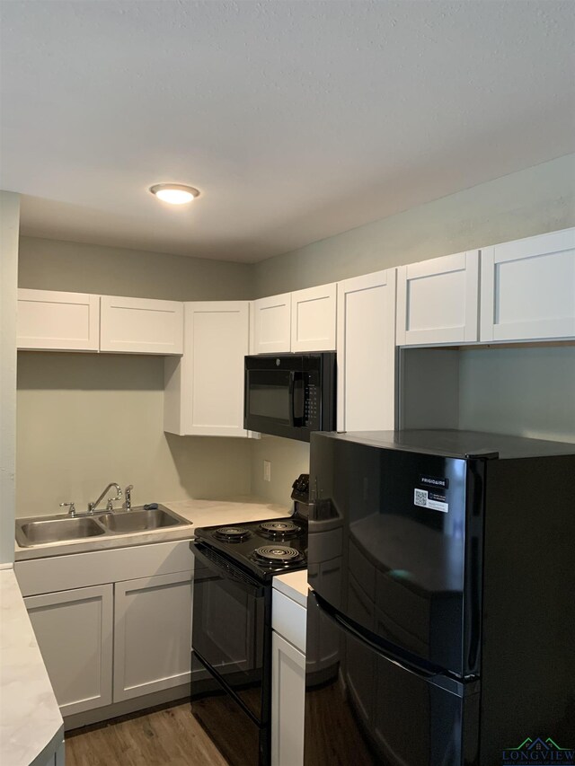 2001 E 20th, Hooks, TX 75561 - kitchen featuring black appliances, a sink, light countertops, and white cabinetry