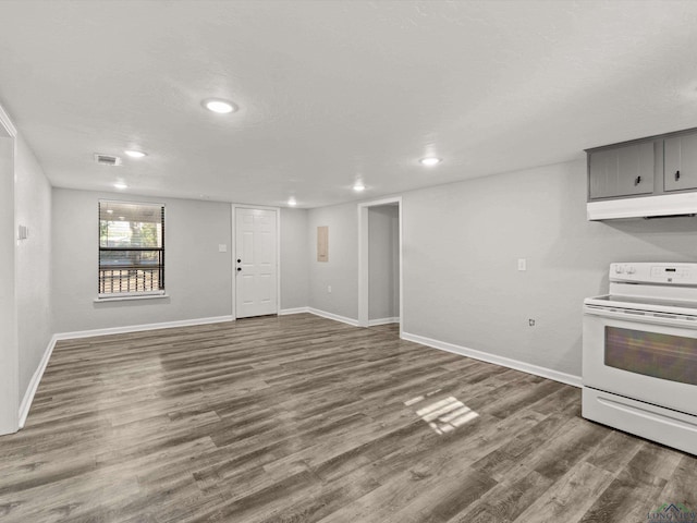 interior space featuring visible vents, wood finished floors, gray cabinets, under cabinet range hood, and white range with electric cooktop