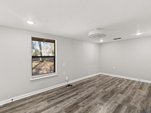 unfurnished room featuring dark wood-type flooring, recessed lighting, visible vents, and baseboards