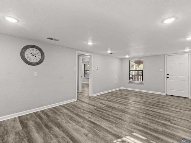 interior space featuring recessed lighting, visible vents, a textured ceiling, wood finished floors, and baseboards