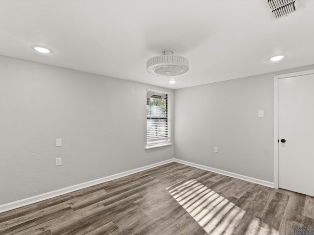 spare room with recessed lighting, wood finished floors, visible vents, and baseboards