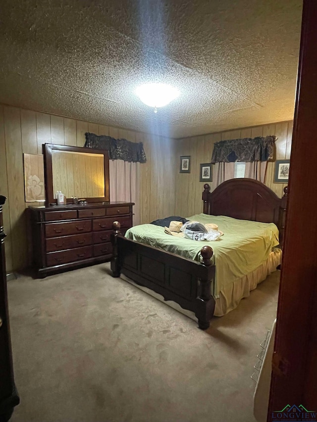 carpeted bedroom with wooden walls and a textured ceiling