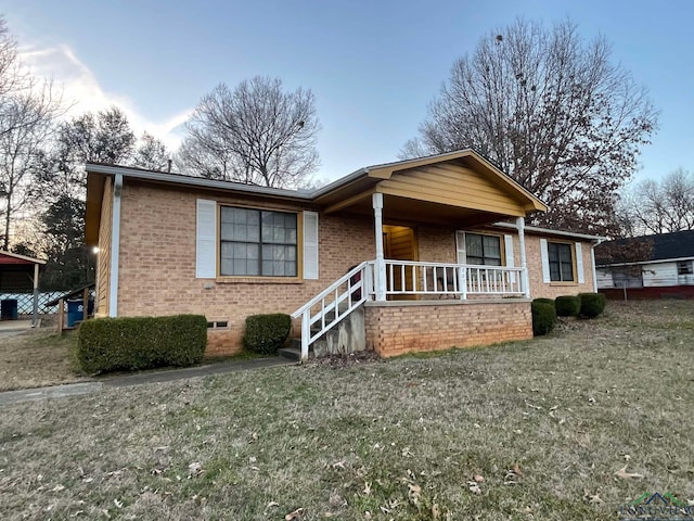 ranch-style house featuring covered porch and brick siding