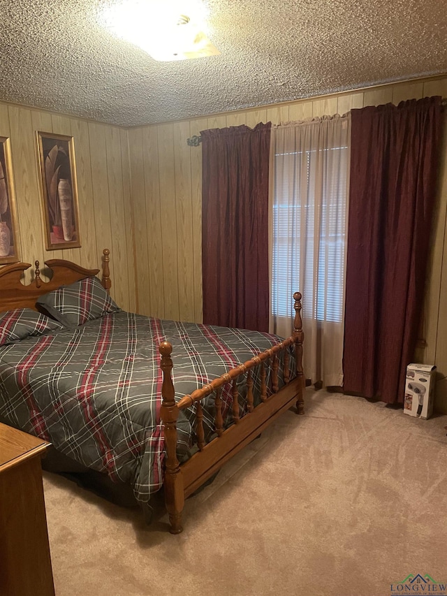 bedroom with a textured ceiling, carpet, and wooden walls