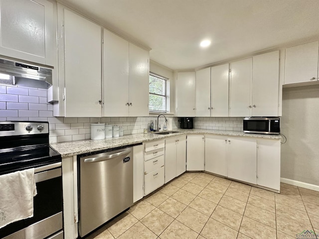 kitchen featuring white cabinets, range hood, and appliances with stainless steel finishes