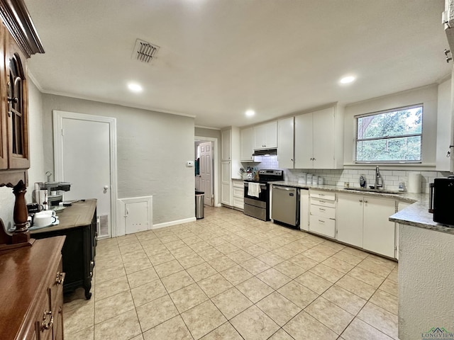 kitchen with white cabinetry, sink, stainless steel appliances, backsplash, and ornamental molding