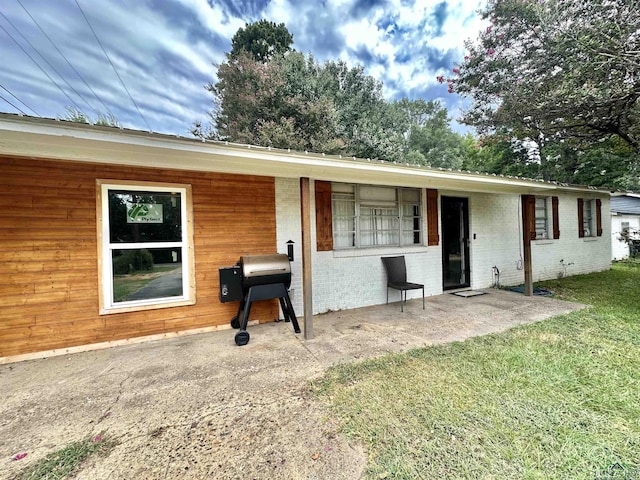 view of front facade with a patio and a front lawn