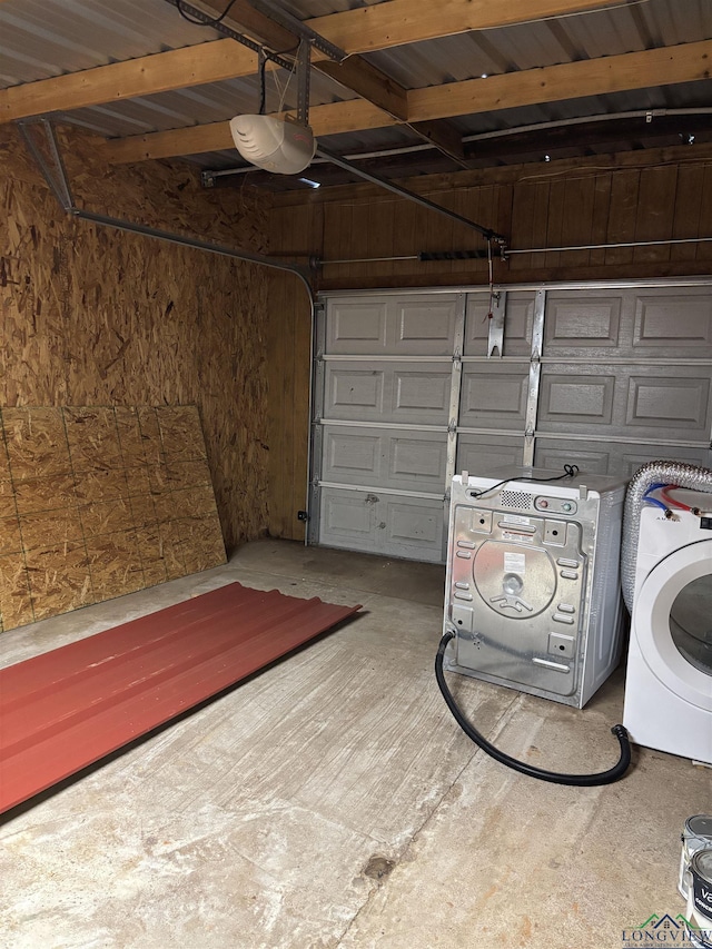 garage featuring wood walls, washer / dryer, and a garage door opener