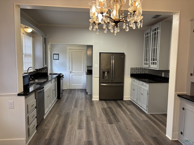 kitchen with pendant lighting, white cabinets, sink, a notable chandelier, and stainless steel appliances