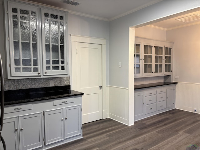 kitchen featuring white cabinets, decorative backsplash, dark hardwood / wood-style floors, and ornamental molding