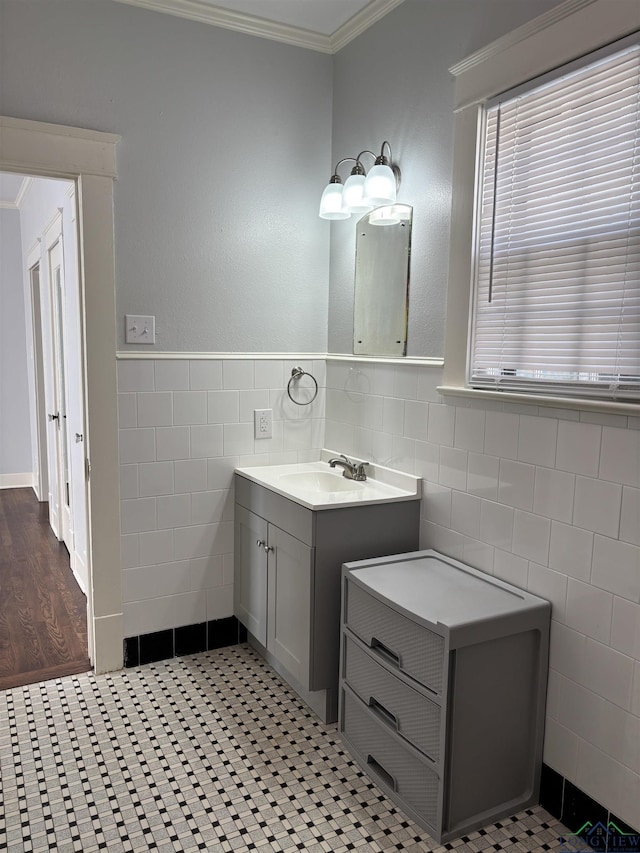 bathroom featuring tile patterned flooring, vanity, ornamental molding, and tile walls