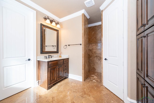 bathroom featuring a tile shower, vanity, and ornamental molding