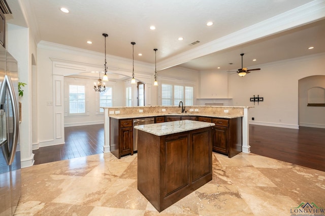 kitchen featuring a large island, stainless steel dishwasher, crown molding, pendant lighting, and ceiling fan with notable chandelier