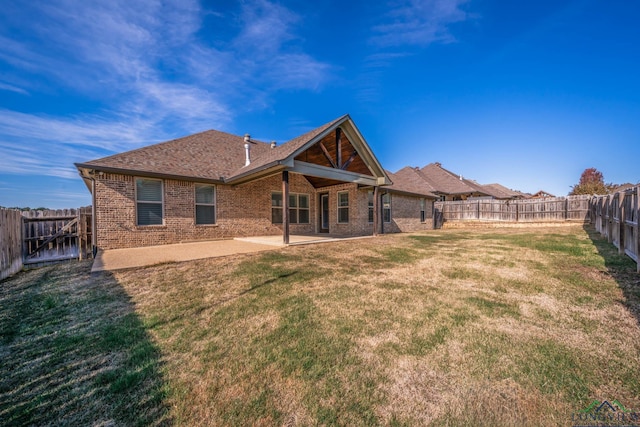 back of property with a patio area and a lawn