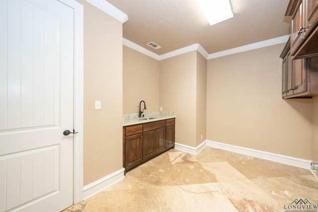 washroom featuring ornamental molding and sink