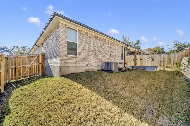 back of property featuring a lawn and central air condition unit