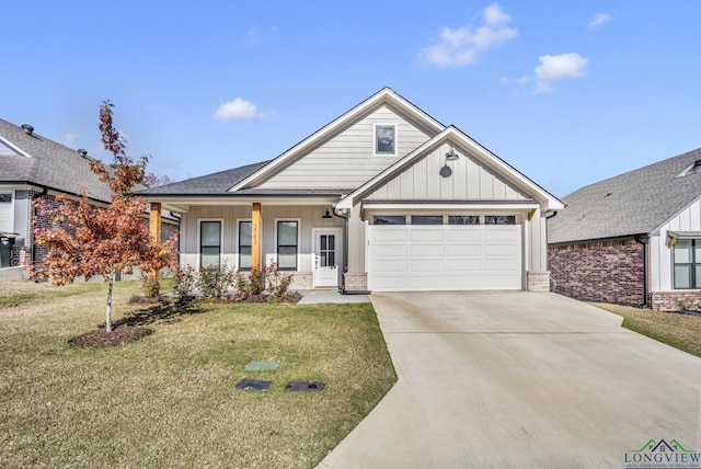 view of front of house with a front yard, a garage, and covered porch