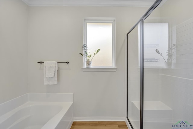 bathroom with wood-type flooring, ornamental molding, and independent shower and bath