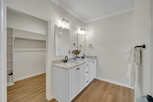 bathroom featuring hardwood / wood-style floors, vanity, and ornamental molding