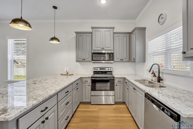 kitchen featuring hanging light fixtures, gray cabinetry, sink, and stainless steel appliances