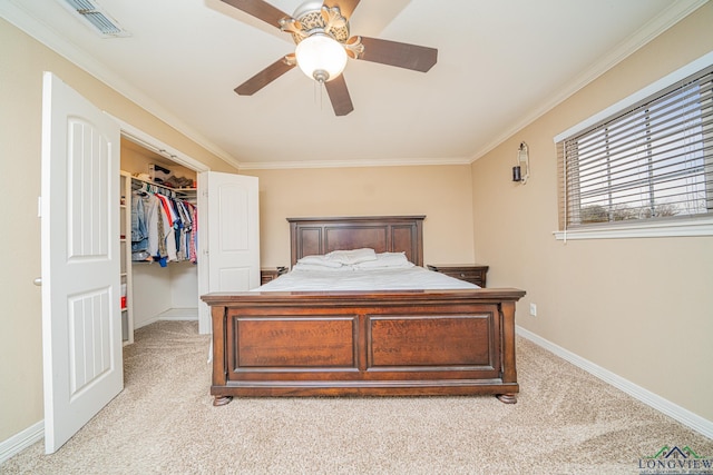 bedroom with a spacious closet, a closet, light colored carpet, crown molding, and ceiling fan