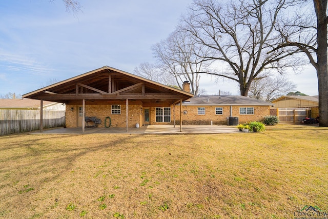 rear view of house featuring a lawn, central air condition unit, and a patio area